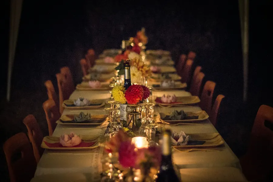 A long candlelit dinner table set with flowers
